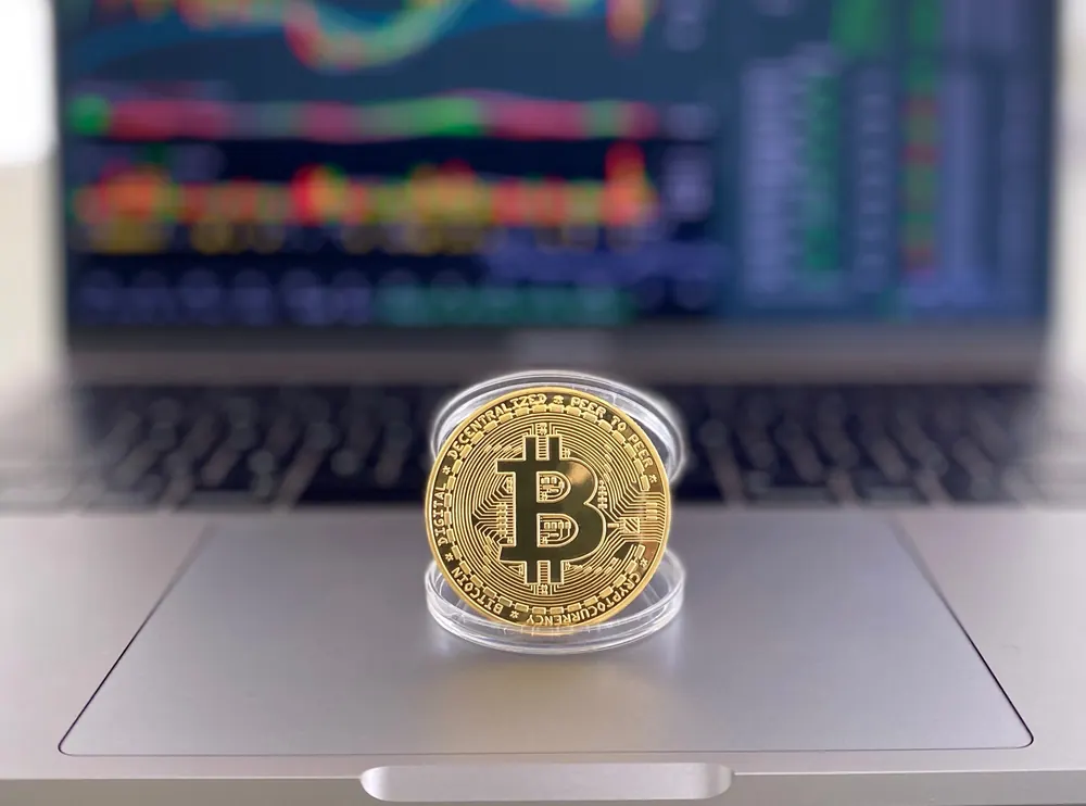 Goudkleurige Bitcoinmunt op een laptop